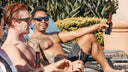 Group of men relaxing poolside with beers on a sunny afternoon