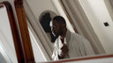 A man in a robe looks at his own reflection in a mirror during his morning routine, illustrating what your skin says about your health.
