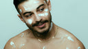 Man applying sunscreen to face and body for UV protection and skin cancer prevention