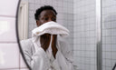 man drying his face in the mirror