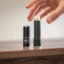 Black lip balm with visible brand name on a wooden surface