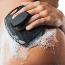 Person using Henkey's Clean Slate Body Scrubber made with 100% silicone on their skin with soap suds.
