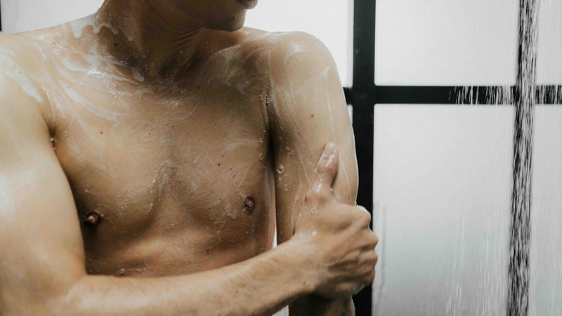 Man applying soap to his arm in a bathroom
