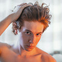 Person with styled hair against a neutral background