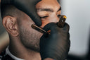 Man get his beard sculpted by a barber